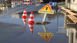 route non praticable car inondée avec un panneau annonçant inondations